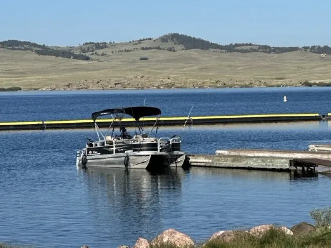 The Sun Tracker pontoon moored on Eleven Mile Reservoir under a clear sky